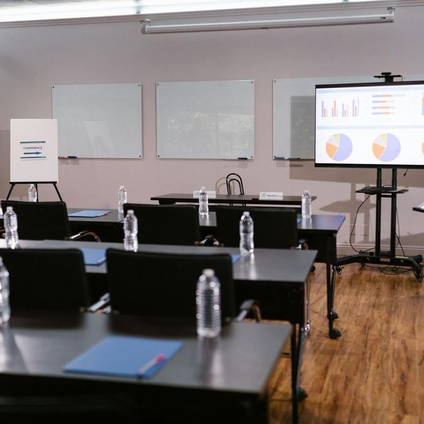 Stopwatch and water bottle on a dark wooden floor.